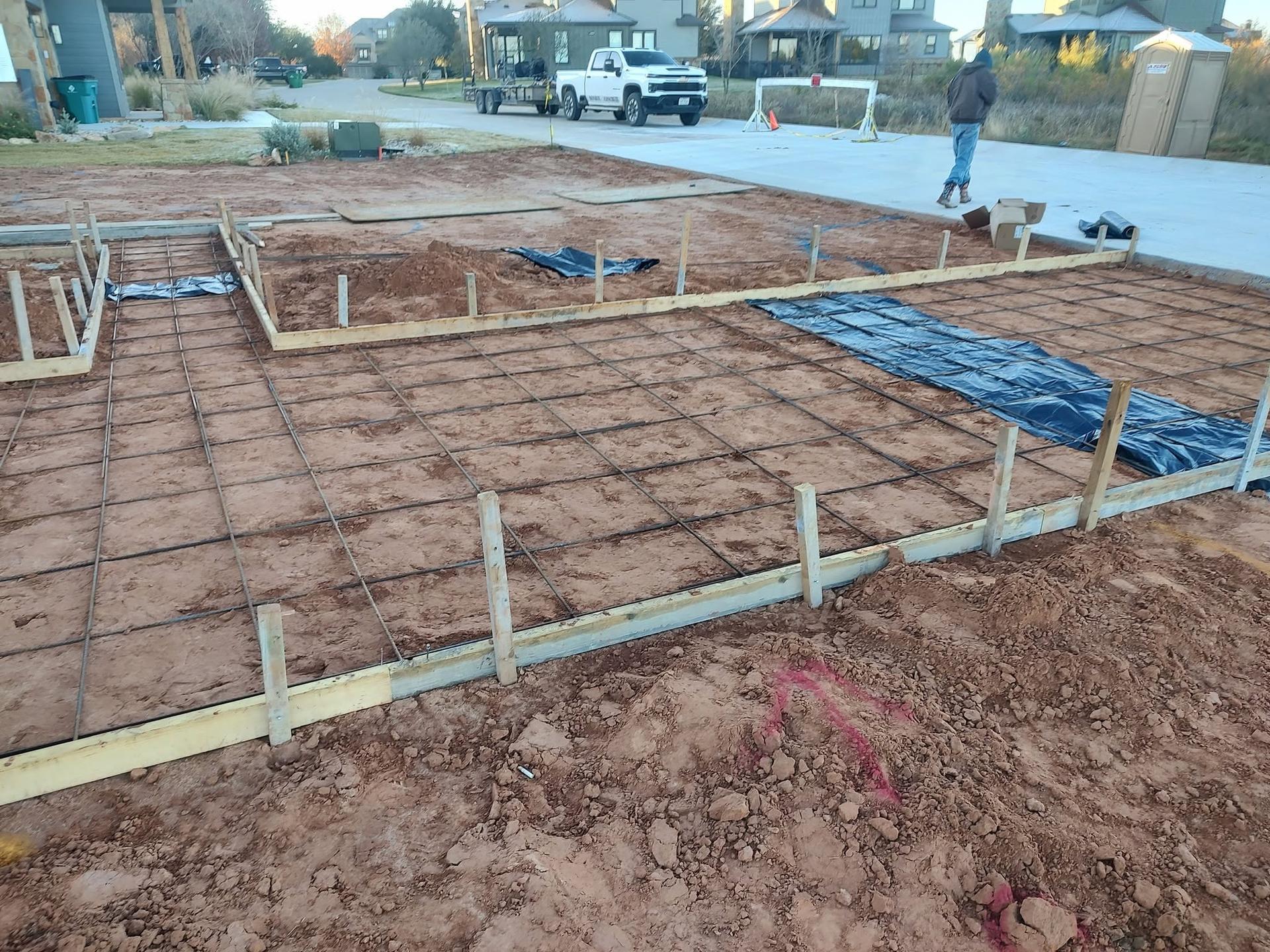 Rebar-reinforced foundation grid staged in a residential neighborhood lot ahead of the pour